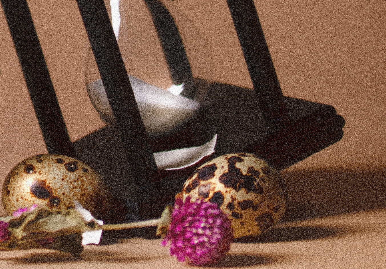 Eggs and hourglass with a pink flower in the foreground